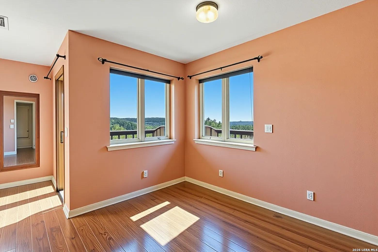 9623 Requa Road Helotes, TX 78023 - Photo 24 of 49 a view of an empty room with wooden floor and a window