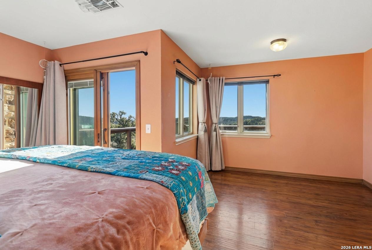 9623 Requa Road Helotes, TX 78023 - Photo 27 of 49 a bedroom with a bed and wooden floor