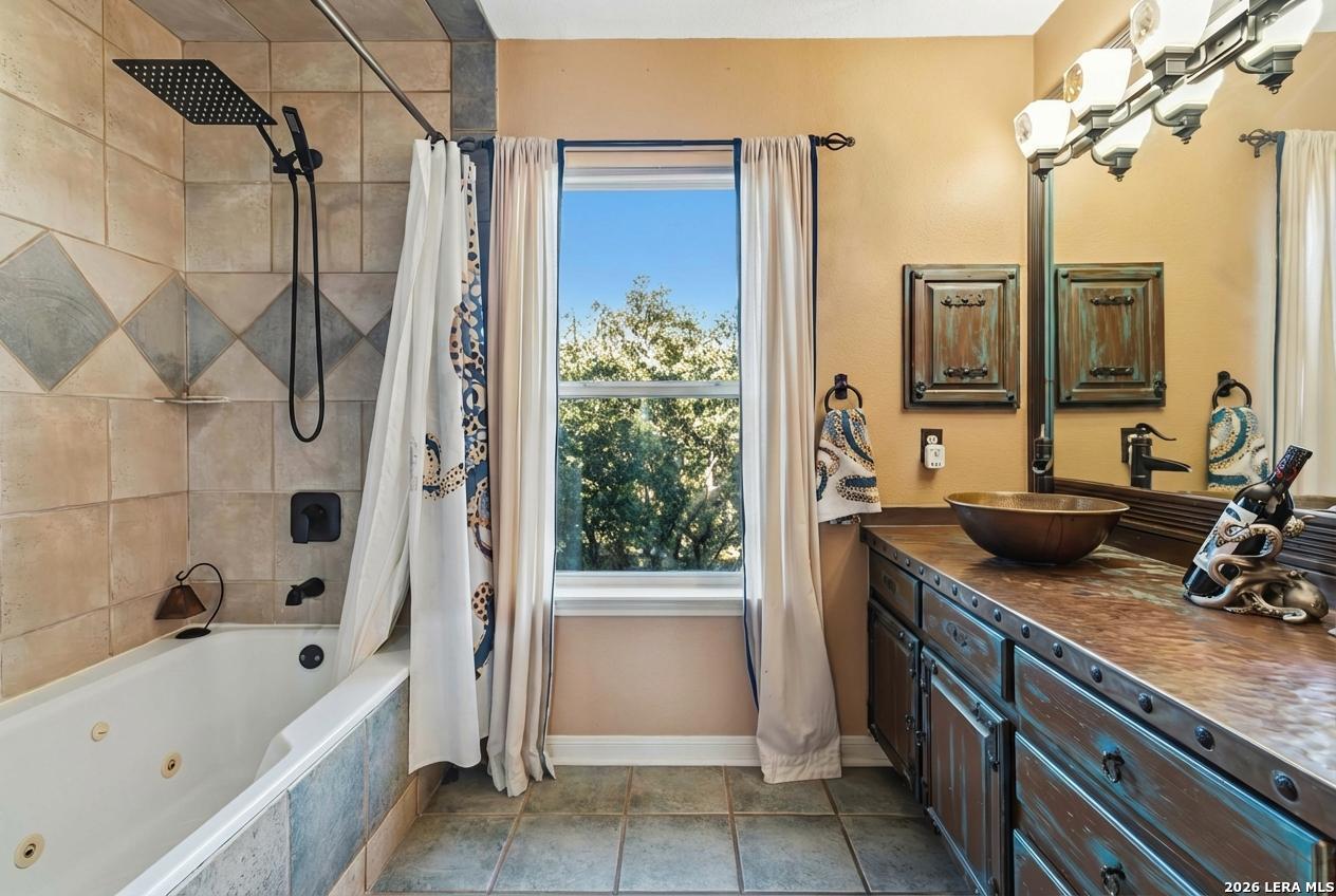 9623 Requa Road Helotes, TX 78023 - Photo 29 of 49 a bathroom with a tub sink and mirror