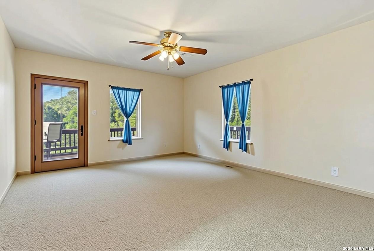9623 Requa Road Helotes, TX 78023 - Photo 34 of 49 an empty room with windows and chandelier fan