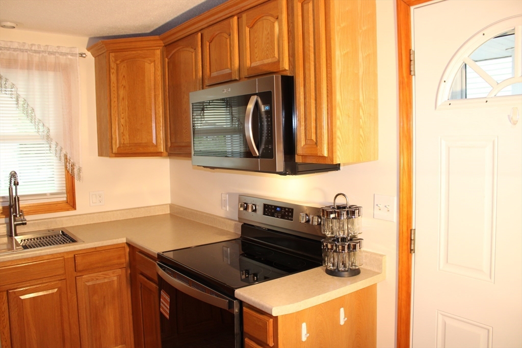 28 State Street Chicopee, MA 01013 - Photo 7 of 25 a kitchen with stainless steel appliances granite countertop a sink and a stove