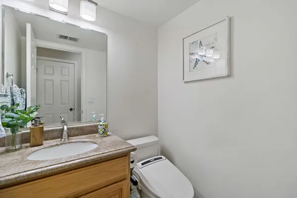 a bathroom with a granite countertop toilet sink and mirror