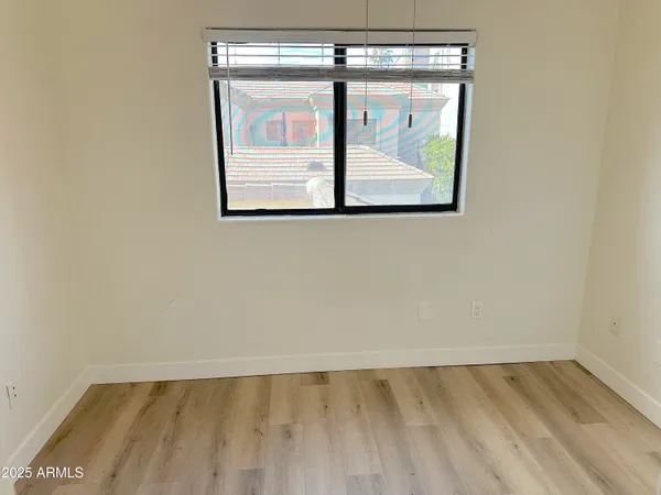 an empty room with a window and a fan
