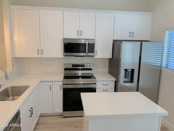 a kitchen with cabinets and steel appliances