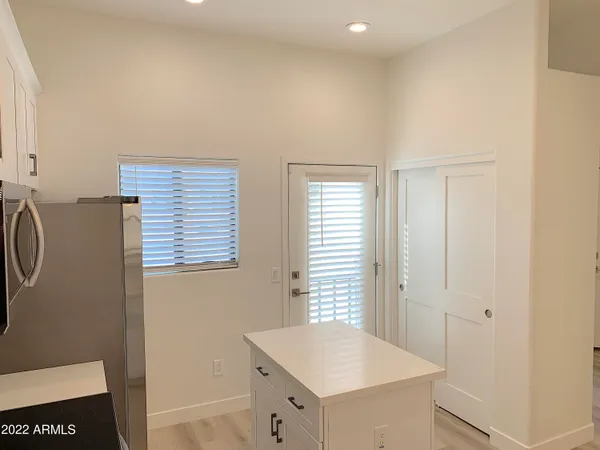 a room with kitchen island a sink a window and chairs