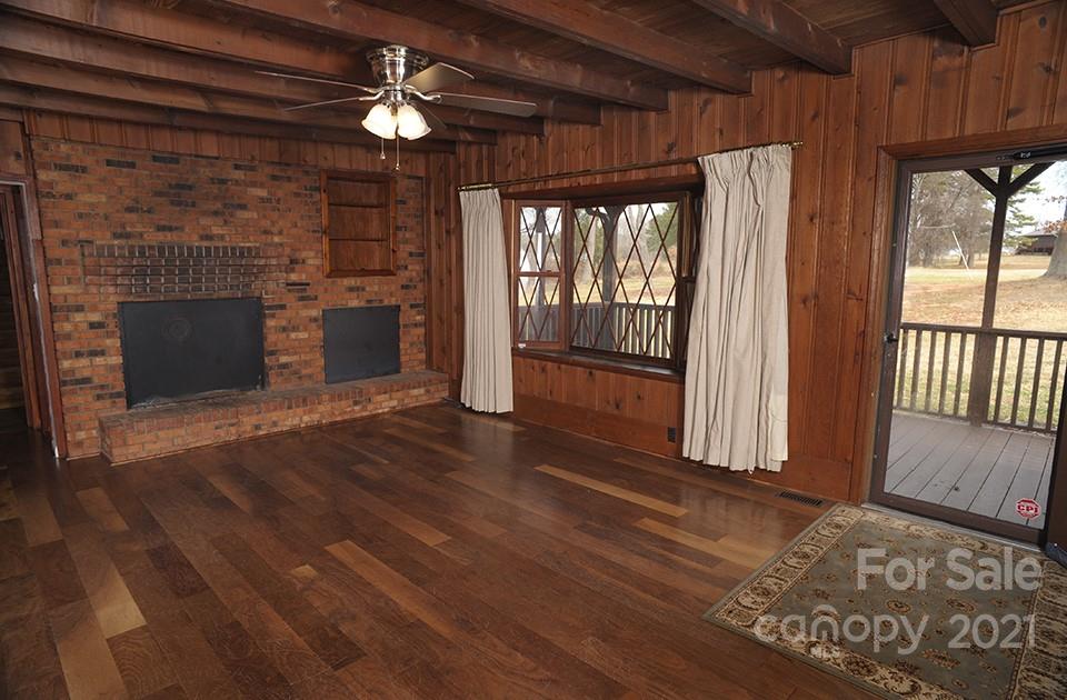 1220 Brison Road Woodleaf, NC 27054 - Photo 4 of 28 a view of an empty room with wooden floor fireplace and a window