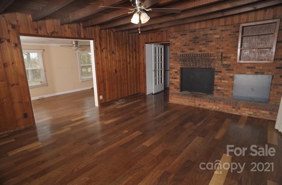 1220 Brison Road Woodleaf, NC 27054 - Photo 5 of 28 a view of empty room with wooden floor and fireplace