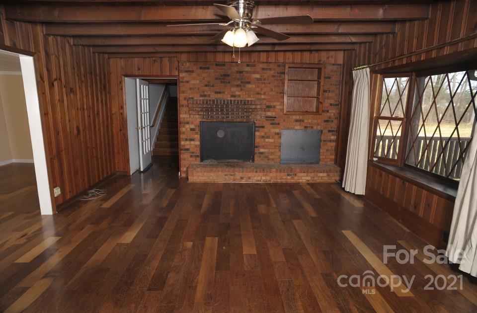 1220 Brison Road Woodleaf, NC 27054 - Photo 6 of 28 a view of a livingroom with wooden floor a fireplace and window