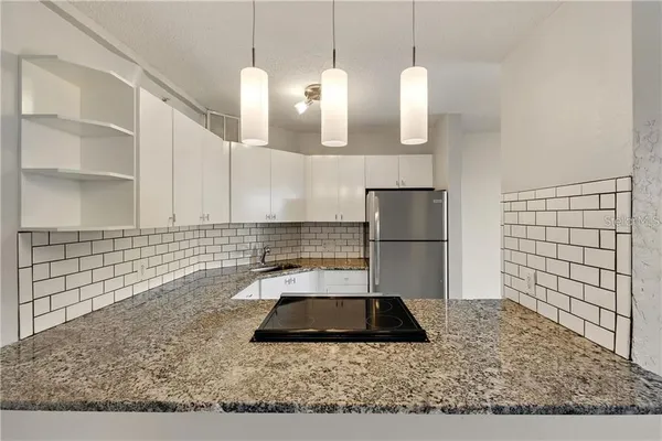 a kitchen with a sink a counter space and stainless steel appliances