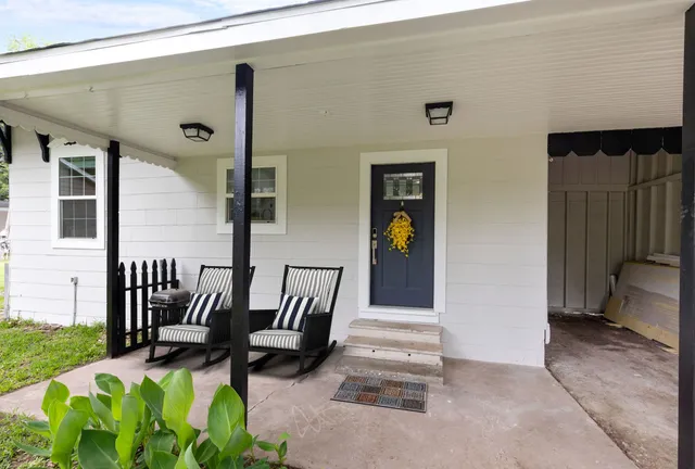 a view of a porch with chairs and backyard