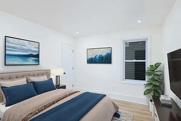 a bedroom with a bed and a painting on the wall