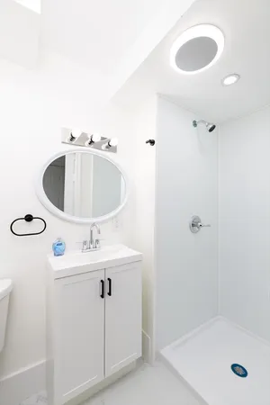 a bathroom with a sink a toilet and shower