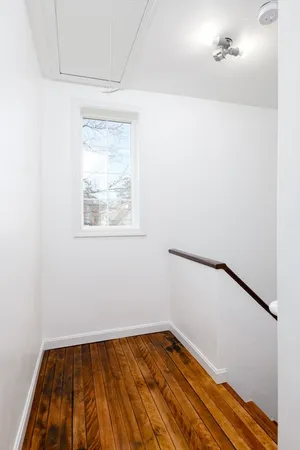 a view of a room with wooden floor and window
