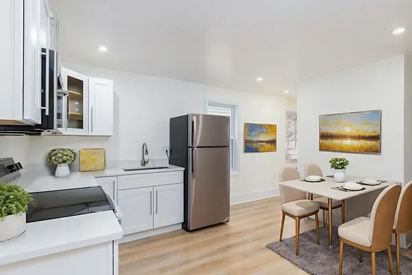 a kitchen with a refrigerator a stove a sink dishwasher with a dining table and chairs