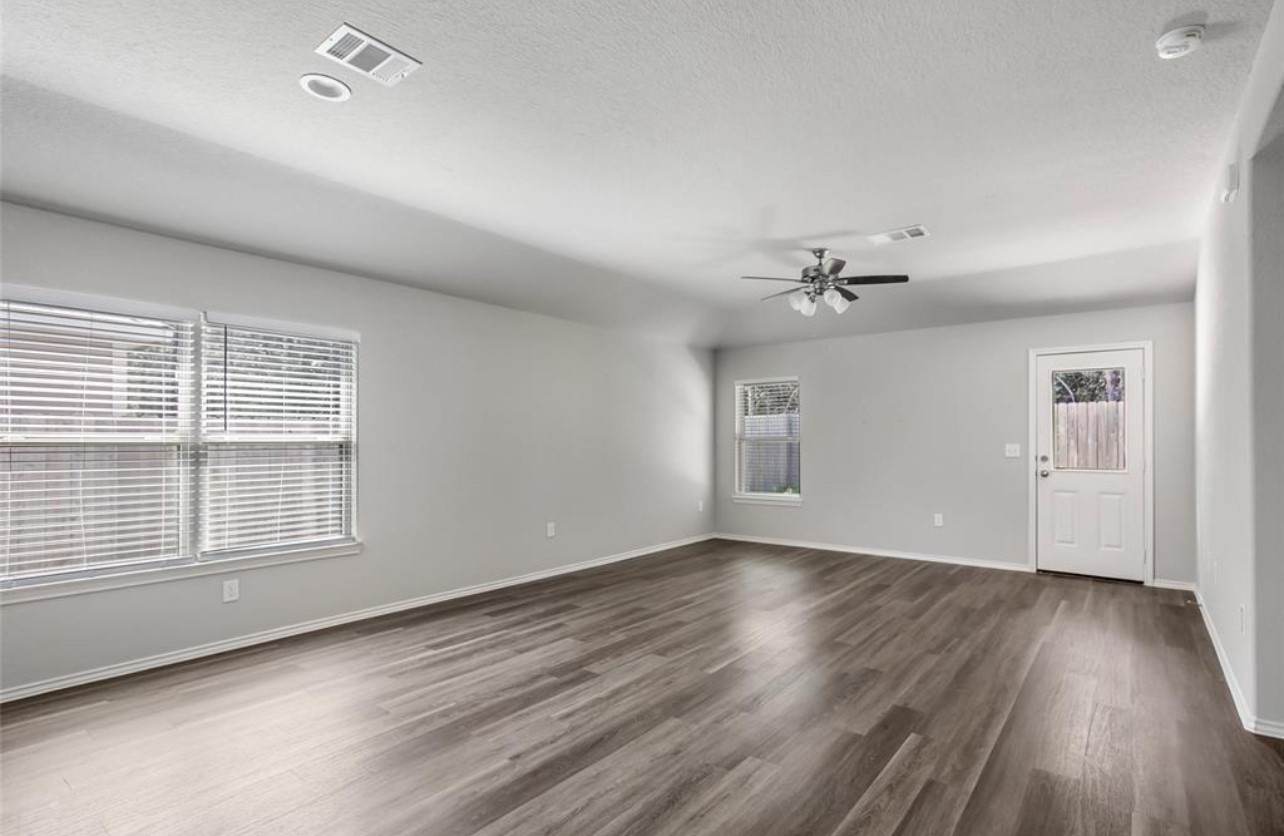 10031 Spring Creek Road Cleveland, TX 77327 - Photo 12 of 18 a view of an empty room with wooden floor and a window