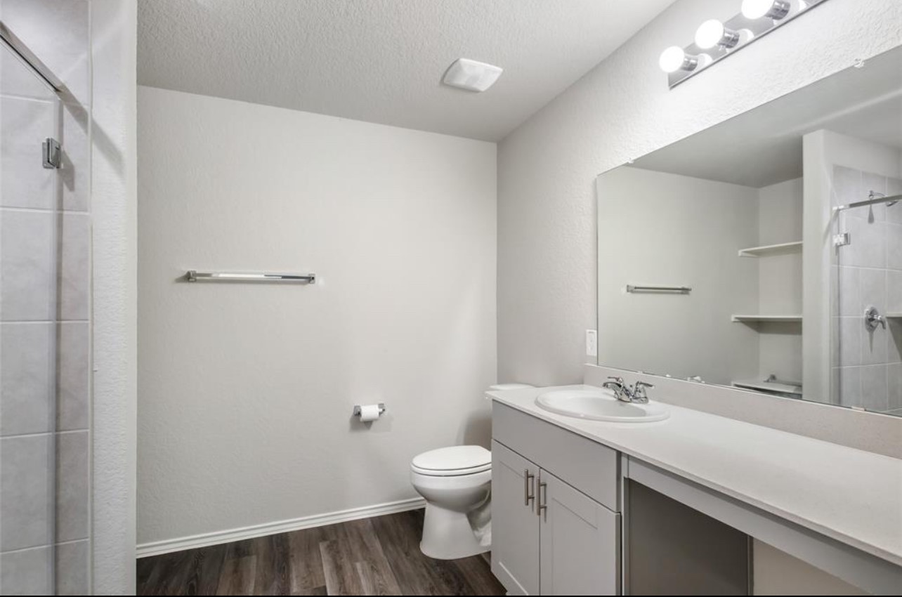 10031 Spring Creek Road Cleveland, TX 77327 - Photo 14 of 18 a bathroom with a toilet a sink and mirror
