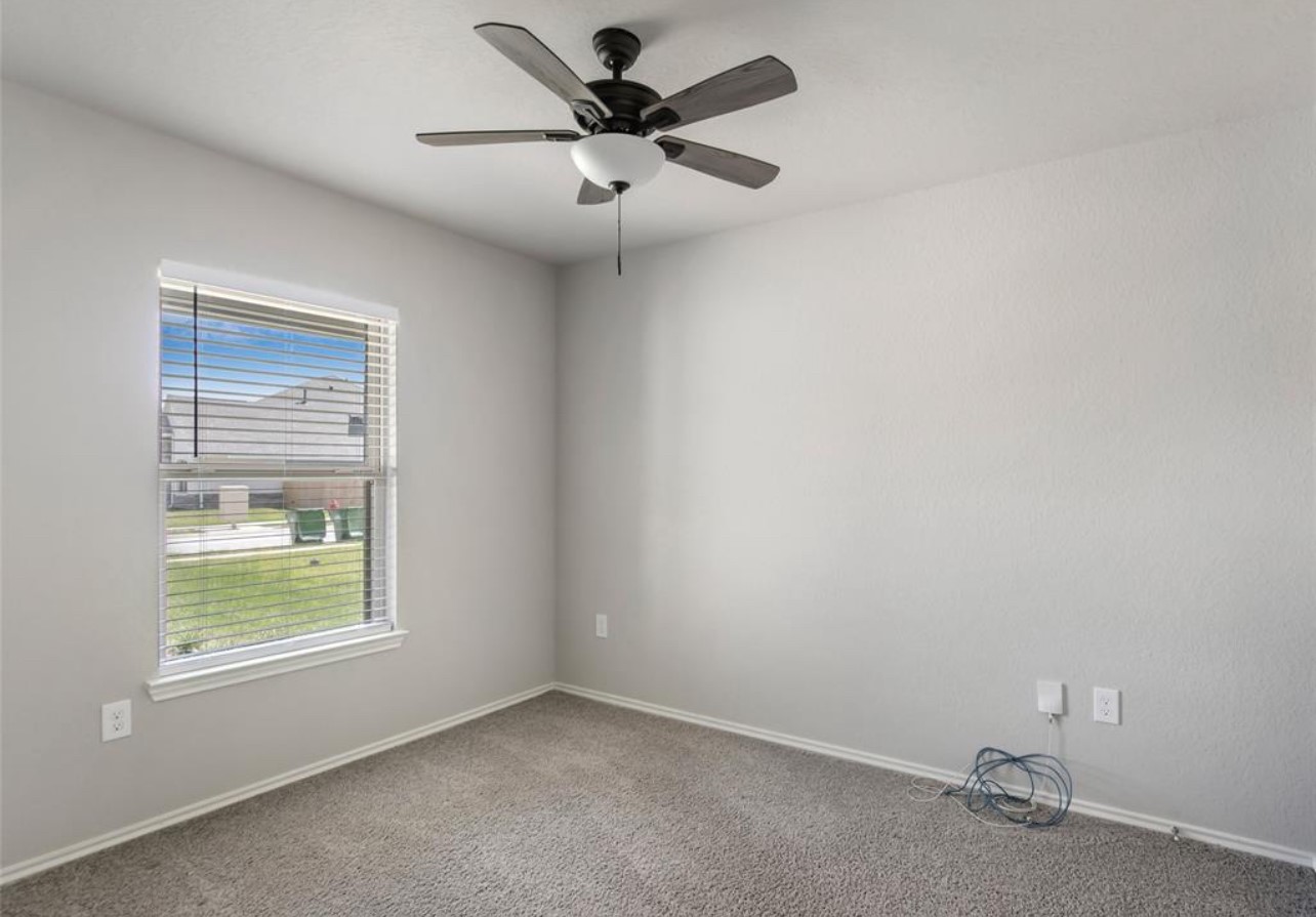 10031 Spring Creek Road Cleveland, TX 77327 - Photo 16 of 18 an empty room with a window and a fan