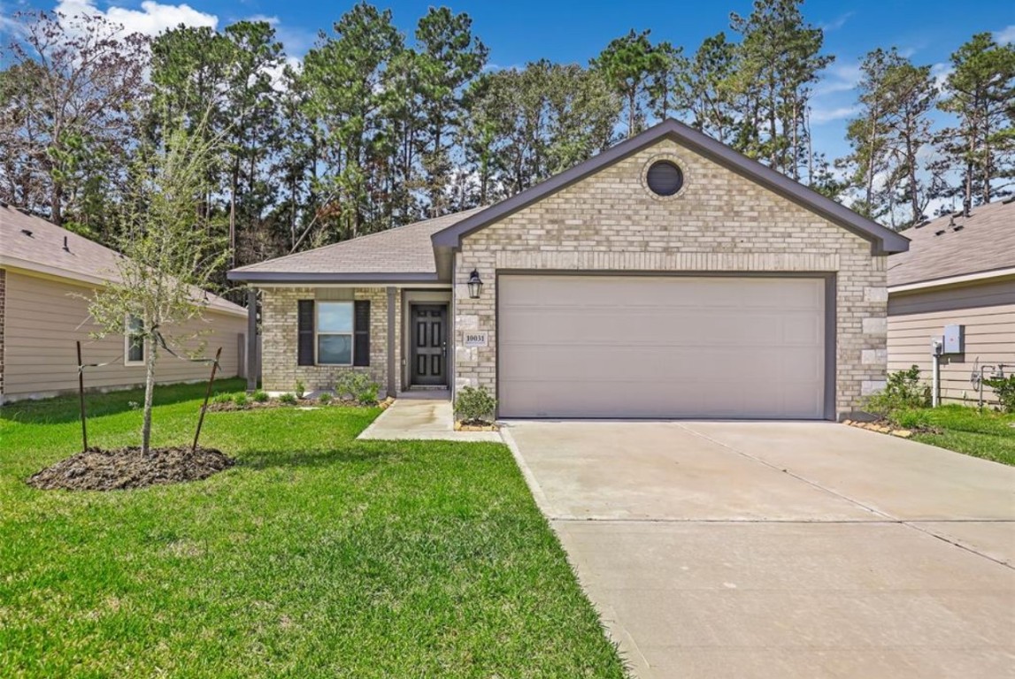10031 Spring Creek Road Cleveland, TX 77327 - Photo 2 of 18 a front view of a house with a yard and garage