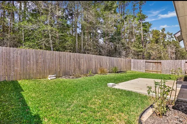a view of backyard with table and chairs and wooden fence