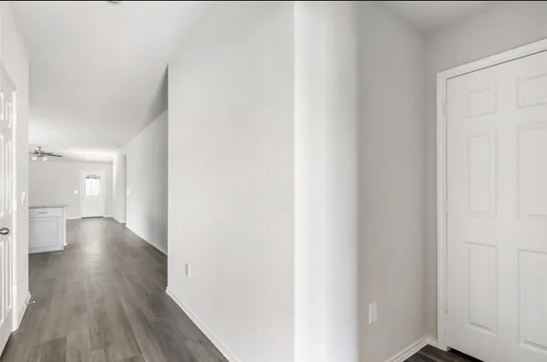 a view of a hallway with wooden floor