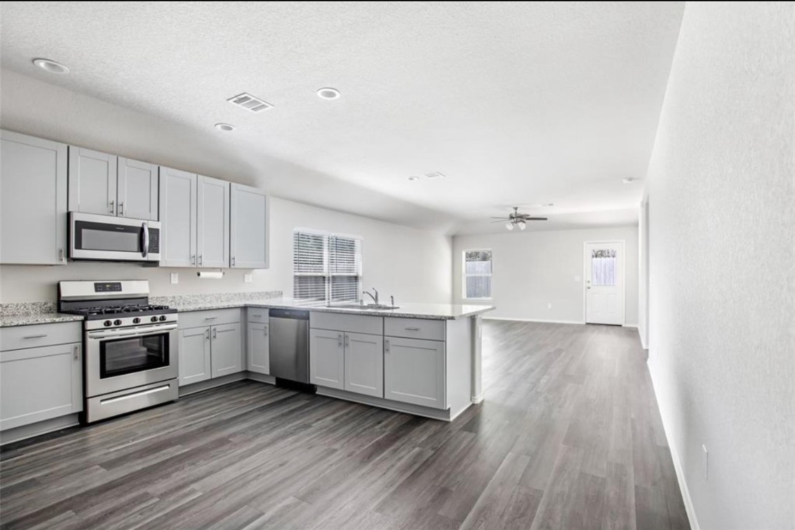 10031 Spring Creek Road Cleveland, TX 77327 - Photo 8 of 18 a kitchen with granite countertop a stove top oven and cabinets