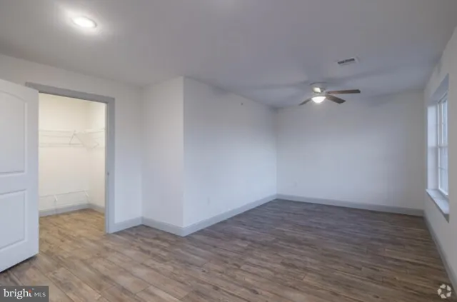 a view of an empty room with wooden floor