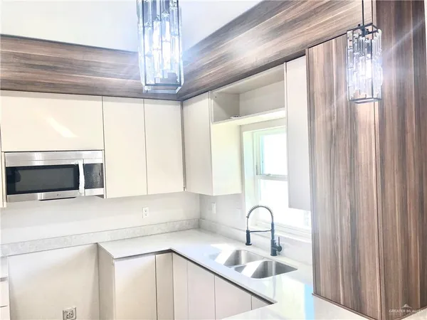 a kitchen with granite countertop a sink stainless steel appliances and cabinets