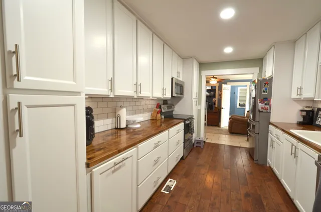 a large kitchen with stainless steel appliances granite countertop a lot of counter space and wooden floors