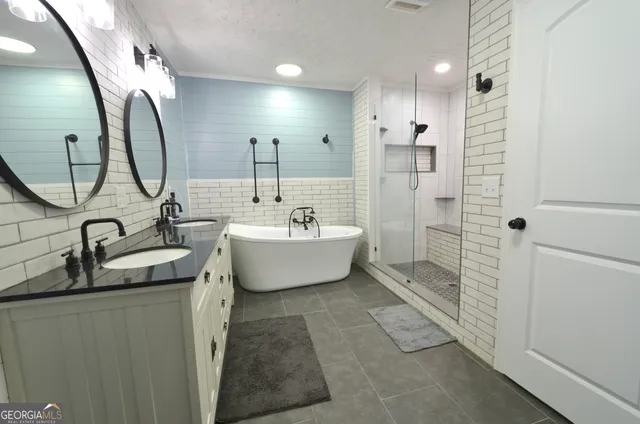 a bathroom with a double vanity sink mirror and shower