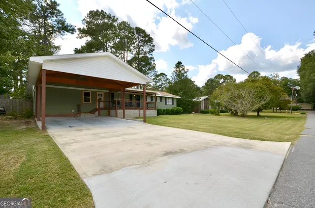a view of a house with backyard and sitting area