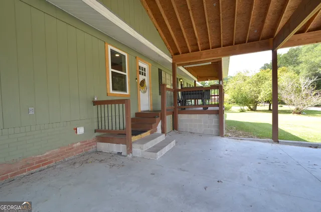 a view of a porch with furniture and garden