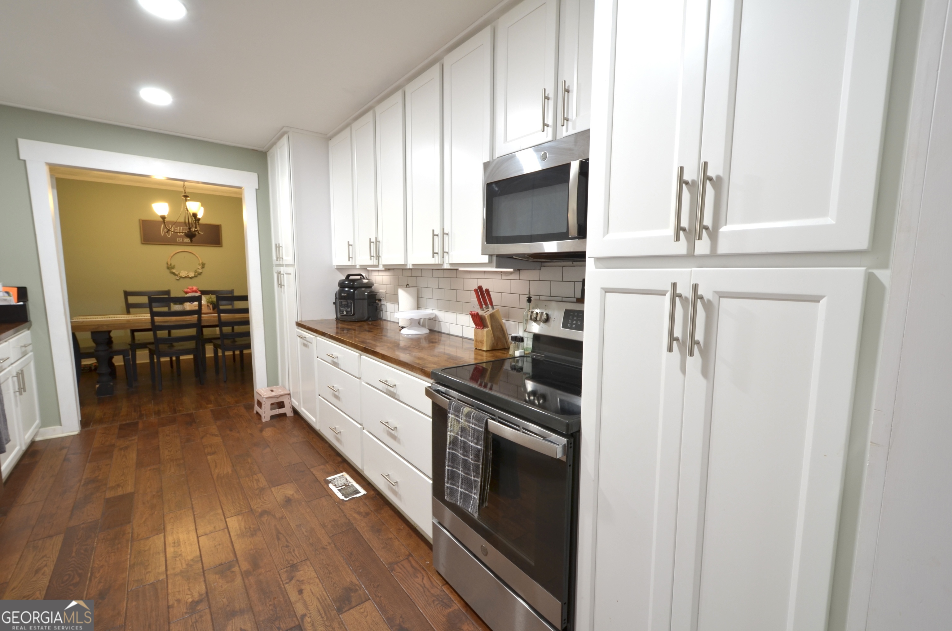 228 Legion Drive Eastman, GA 31023 - Photo 9 of 37 a kitchen with stainless steel appliances white cabinets and wooden floor