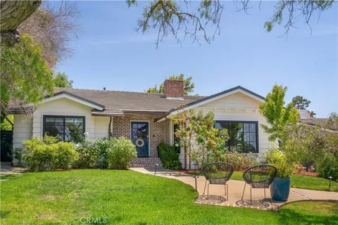 a front view of a house with a yard and potted plants