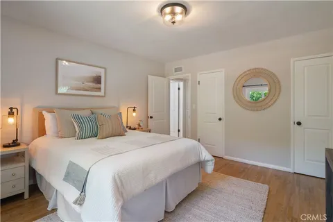 a bedroom with a bed and a lamp on dresser