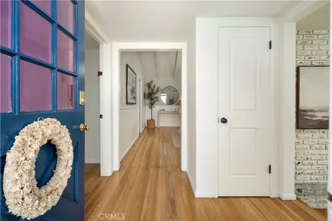a view of a hallway with wooden floor and front door
