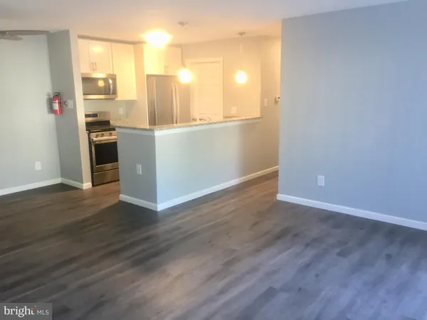 a view of a kitchen with wooden floor and a refrigerator