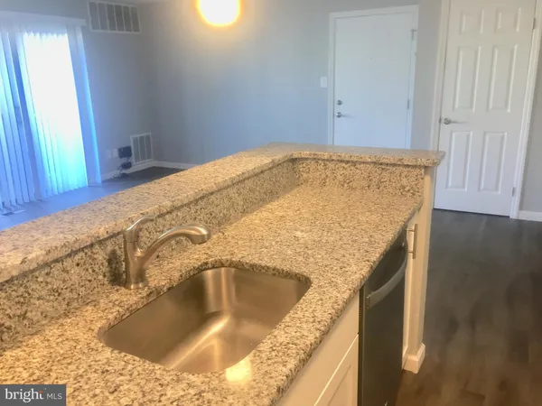 a kitchen with granite countertop a sink a stove and a microwave