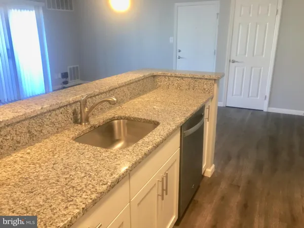 a view of a kitchen with wooden floor and electronic appliances