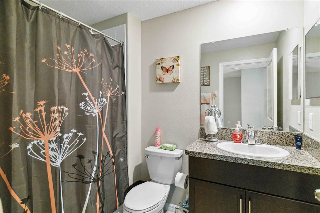 14339 Easy Goer Street Ruskin, FL 33573 - Photo 33 of 49 a bathroom with a granite countertop sink toilet and a shower