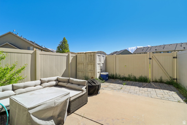 1077 South 1850th Street West Springville, UT 84663 - Photo 20 of 22 Fenced backyard featuring a gate, a patio area, an outdoor living space, and a storage unit