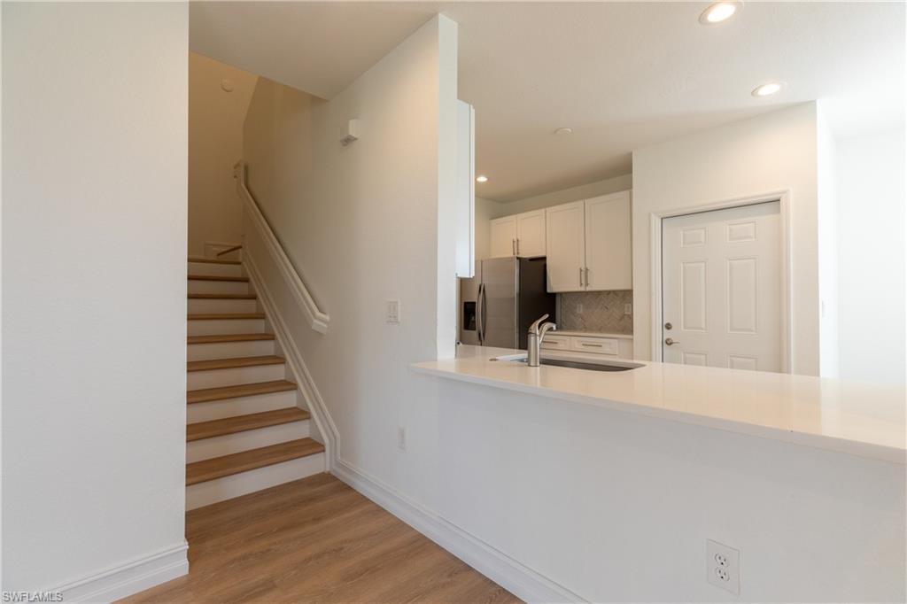 15618 Summit Pl Circle, Unit 396 Naples, FL 34119 - Photo 13 of 41 a view of kitchen and hallway with wooden floor