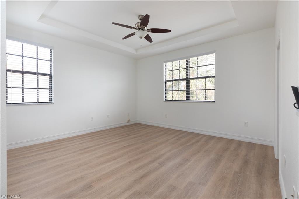15618 Summit Pl Circle, Unit 396 Naples, FL 34119 - Photo 15 of 41 an empty room with wooden floor and windows