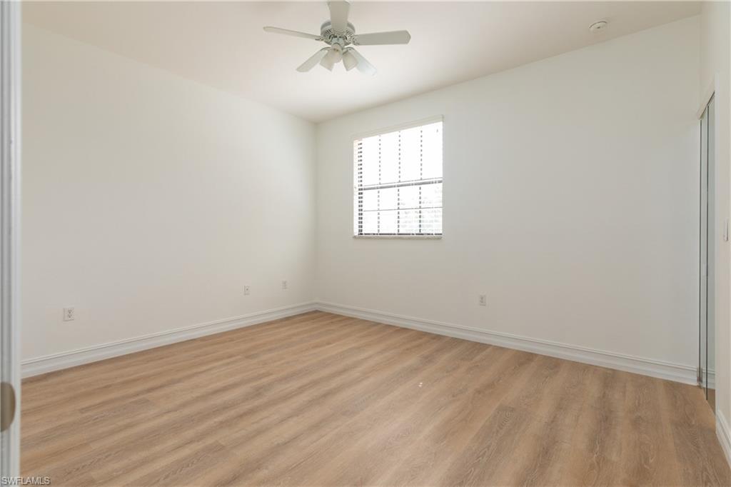 15618 Summit Pl Circle, Unit 396 Naples, FL 34119 - Photo 17 of 41 wooden floor in an empty room with a window