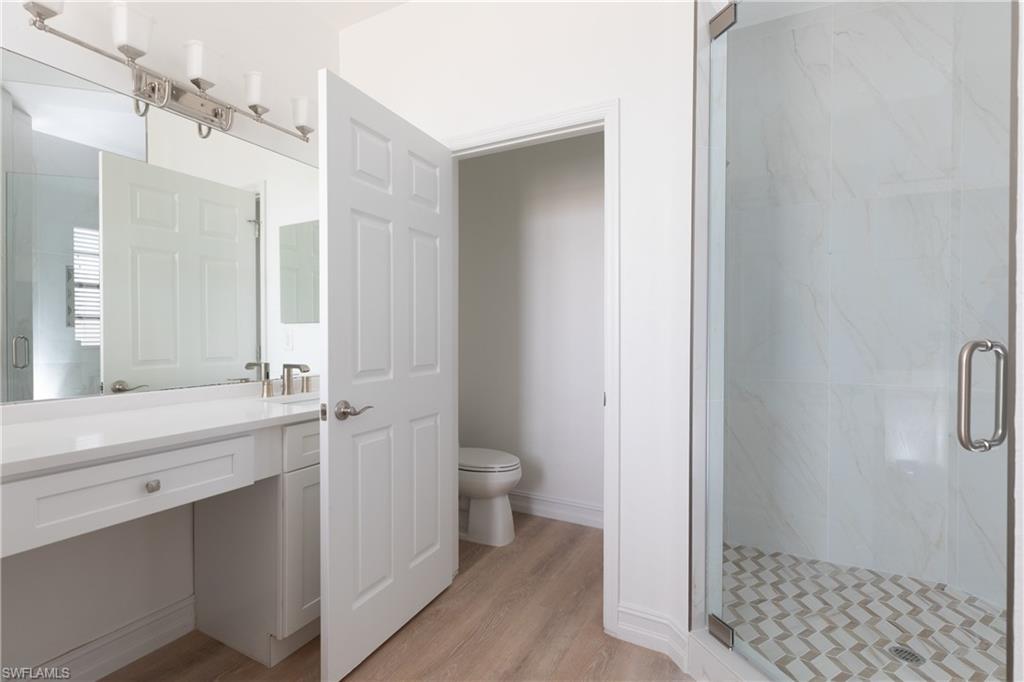 15618 Summit Pl Circle, Unit 396 Naples, FL 34119 - Photo 19 of 41 a bathroom with a granite countertop sink toilet and shower
