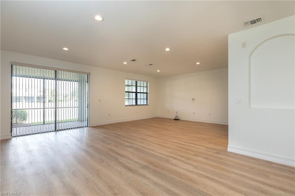 15618 Summit Pl Circle, Unit 396 Naples, FL 34119 - Photo 2 of 41 an empty room with wooden floor and windows