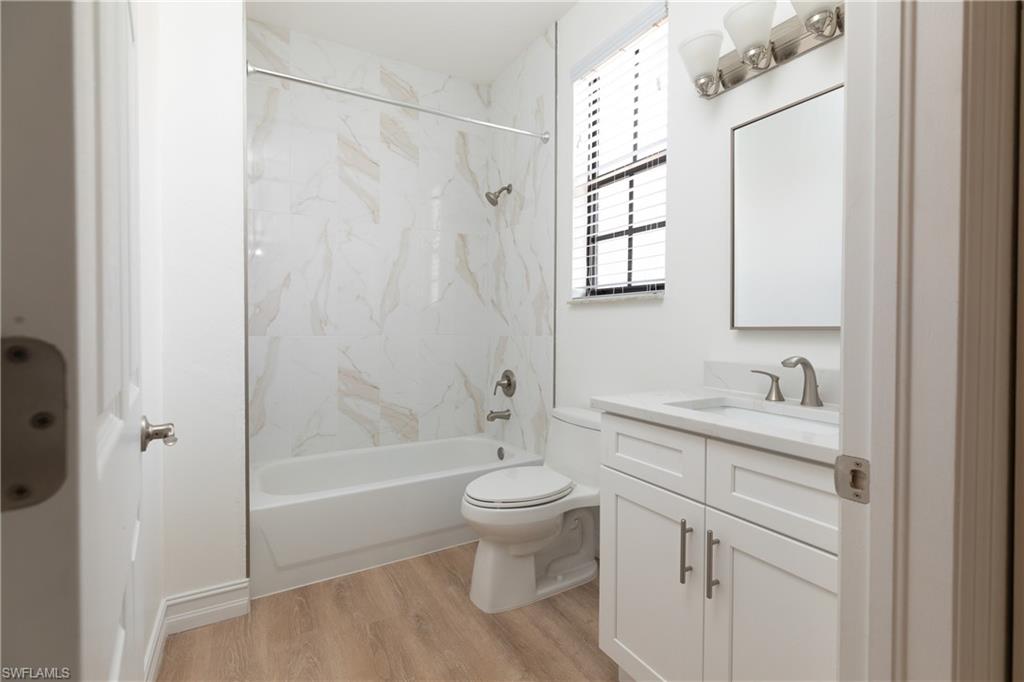 15618 Summit Pl Circle, Unit 396 Naples, FL 34119 - Photo 22 of 41 a bathroom with a granite countertop sink a toilet and shower