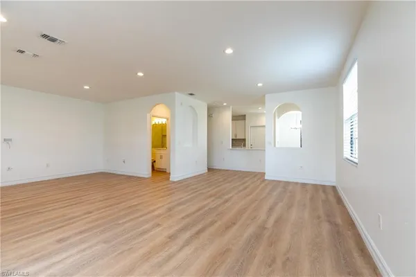 a view of empty room with wooden floor and window