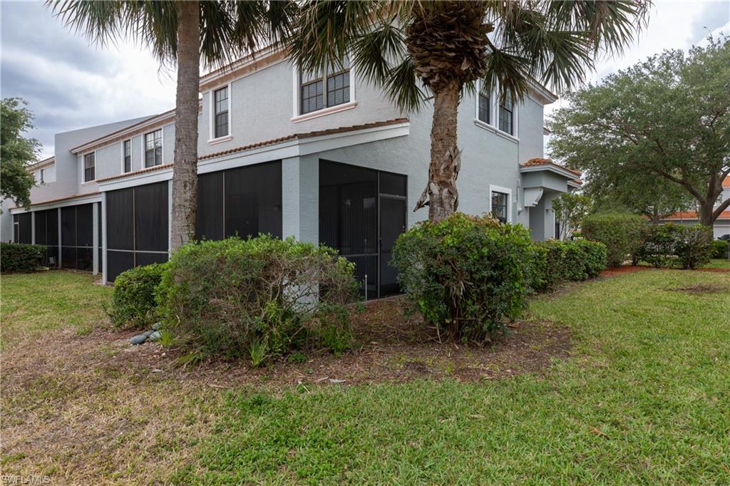 15618 Summit Pl Circle, Unit 396 Naples, FL 34119 - Photo 33 of 41 front view of house with a yard and palm trees