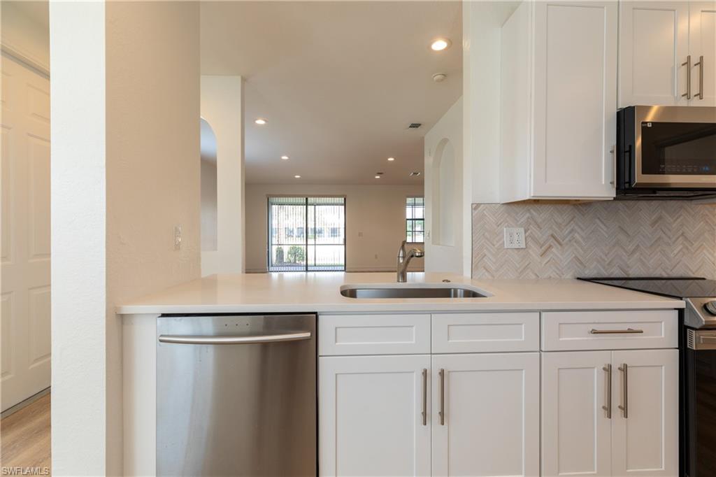 15618 Summit Pl Circle, Unit 396 Naples, FL 34119 - Photo 4 of 41 a kitchen with stainless steel appliances white cabinets and a sink