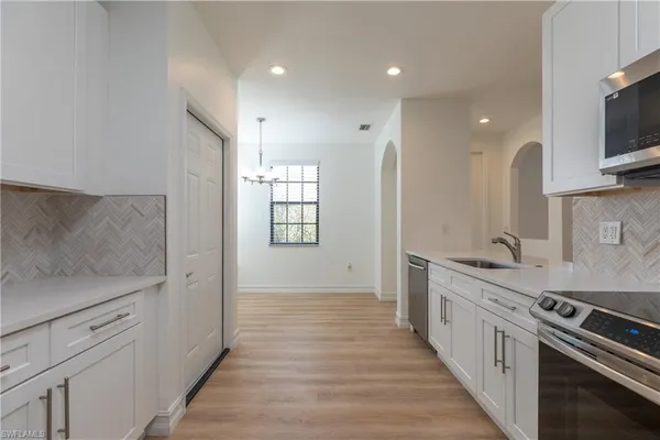 a large kitchen with stainless steel appliances granite countertop a lot of counter space and wooden floor